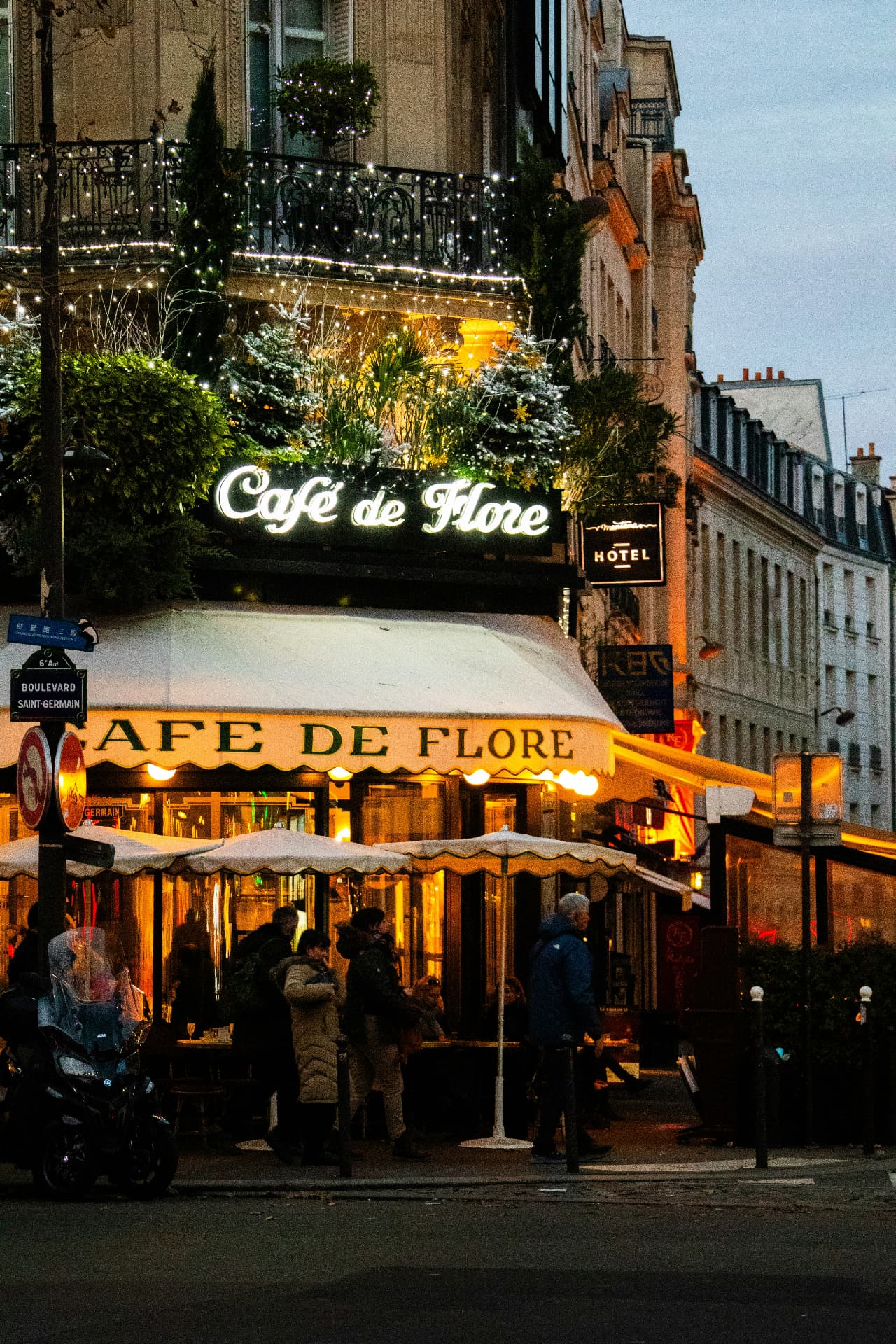 Café de Flore on Boulevard Saint-Germain at dusk, glowing awnings and festive lights